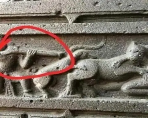 Ancient Indian stone carving depicting a warrior with a firearm-like object and an animal attacking a person.